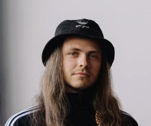 Denis — drums of 5051, black Adidas jacket and bucket hat